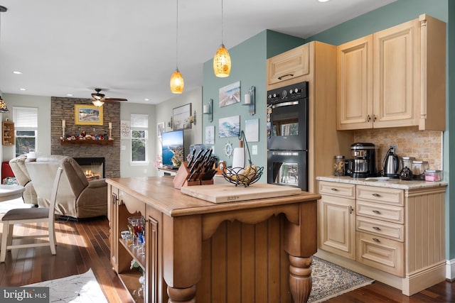 kitchen featuring dark wood-type flooring, pendant lighting, dobule oven black, and open floor plan