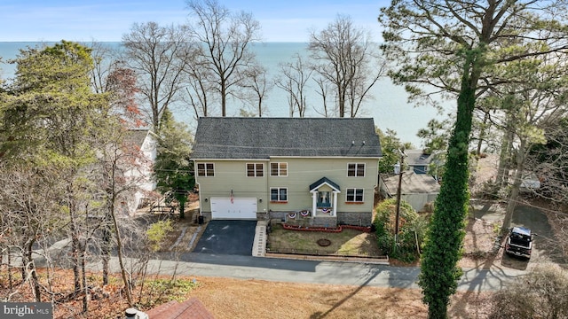 view of front of property with a garage, a water view, and aphalt driveway