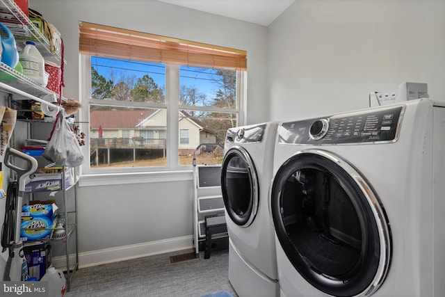 washroom with laundry area, washing machine and dryer, baseboards, and carpet