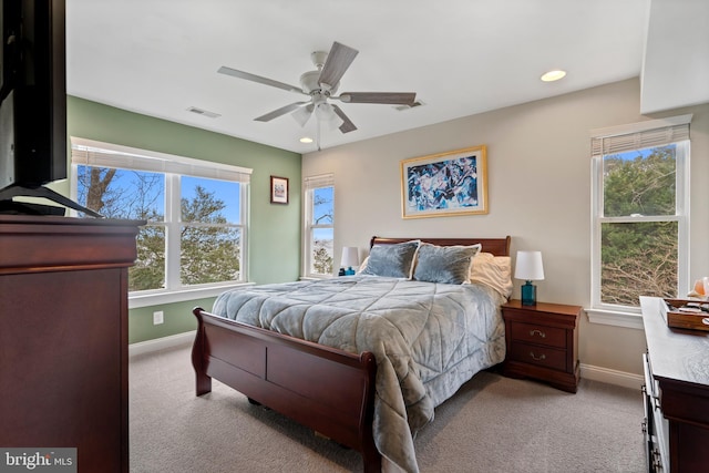 bedroom featuring baseboards, multiple windows, and light colored carpet