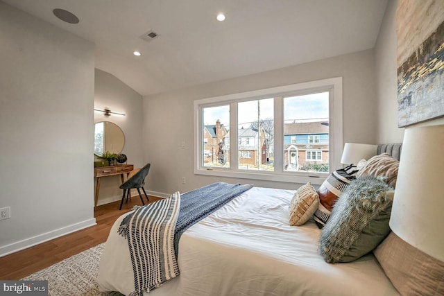 bedroom with vaulted ceiling and hardwood / wood-style floors