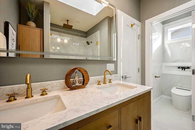 bathroom with toilet, a tile shower, vanity, and a skylight