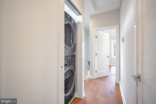 washroom featuring stacked washer and dryer and light hardwood / wood-style floors