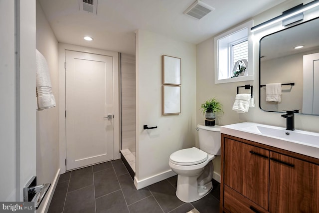 bathroom featuring tile patterned flooring, vanity, walk in shower, and toilet