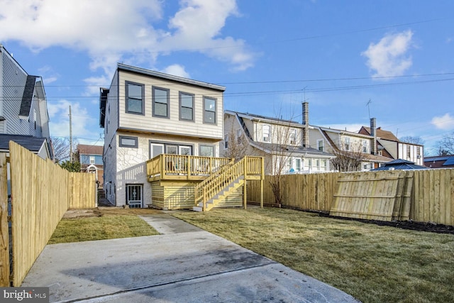 rear view of house with a lawn and a deck