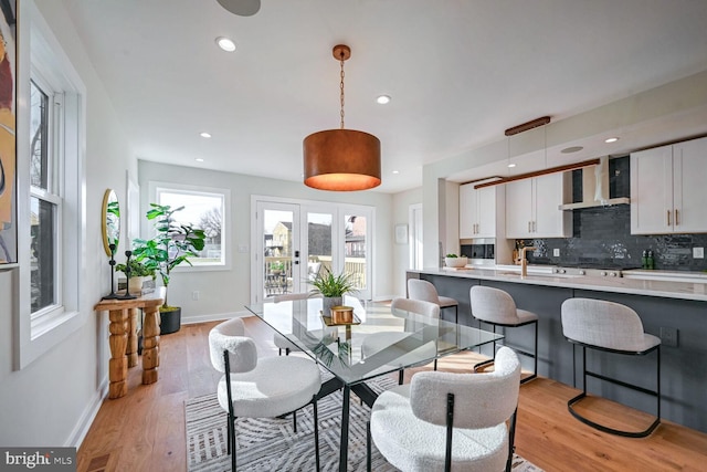 dining area with french doors, sink, and light hardwood / wood-style flooring