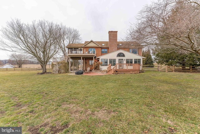 rear view of property with a yard, a deck, and a patio area