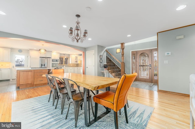 dining space featuring light hardwood / wood-style flooring and a notable chandelier