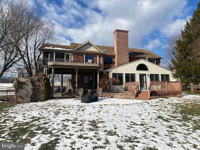 snow covered property with a wooden deck