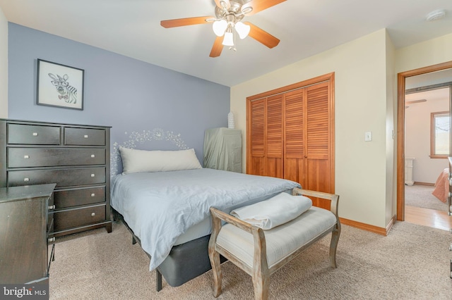 bedroom featuring light colored carpet, a closet, and ceiling fan