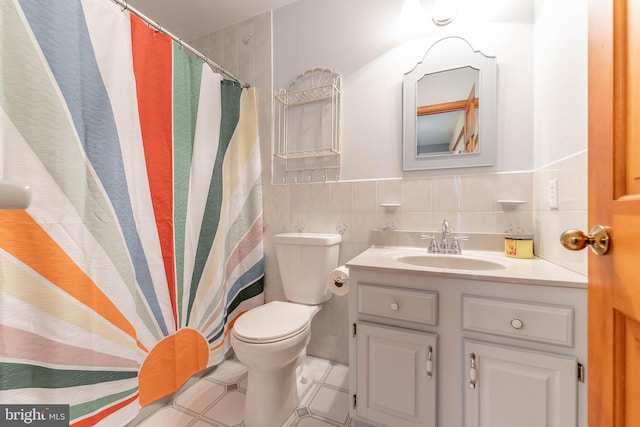 bathroom featuring tile walls, vanity, and toilet