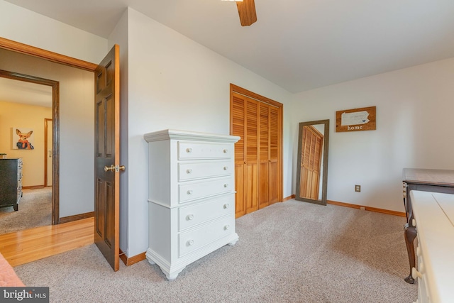 carpeted bedroom featuring ceiling fan and a closet