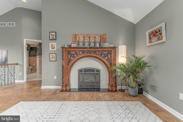 living room featuring lofted ceiling and hardwood / wood-style floors