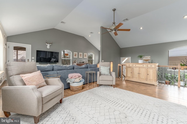 living room with vaulted ceiling, ceiling fan, and light hardwood / wood-style floors