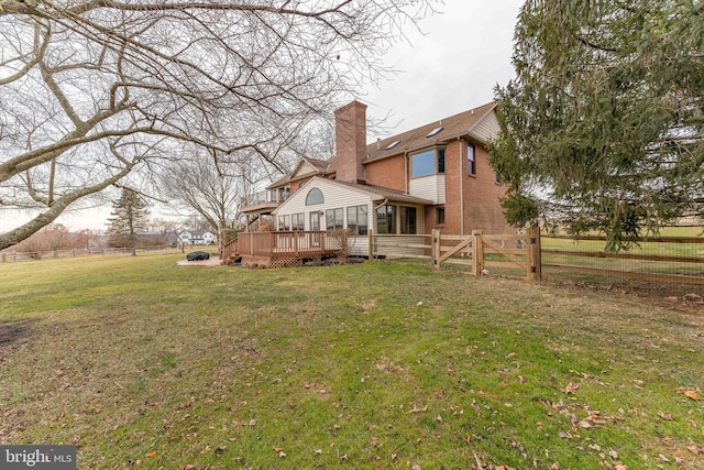 back of house with a deck and a lawn