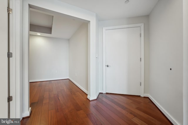 hallway with dark hardwood / wood-style flooring