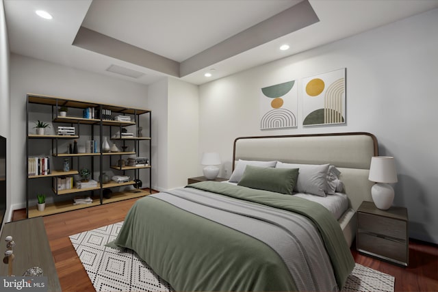 bedroom featuring hardwood / wood-style floors and a tray ceiling