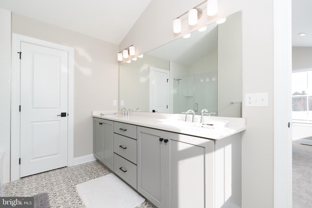 bathroom featuring a shower with door, vanity, lofted ceiling, and tile patterned floors