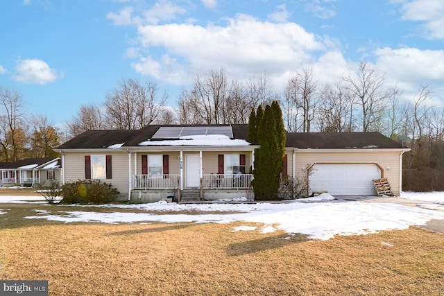 ranch-style home with a porch, a garage, a yard, and solar panels