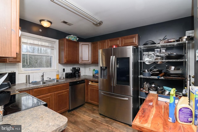 kitchen with tasteful backsplash, appliances with stainless steel finishes, sink, and dark hardwood / wood-style flooring