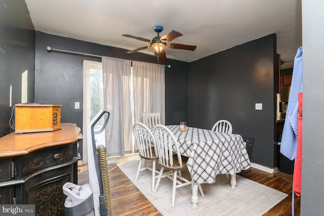 dining area with ceiling fan and dark hardwood / wood-style flooring