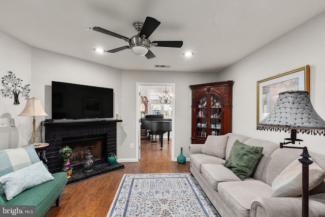 living room with hardwood / wood-style flooring, ceiling fan, and a fireplace