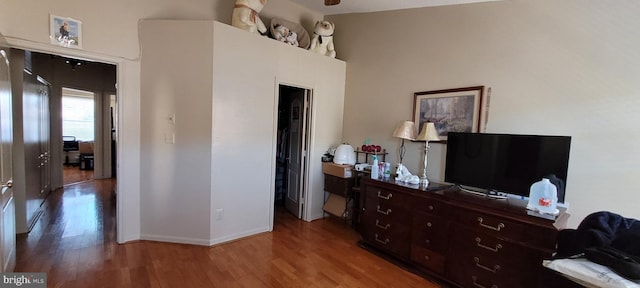 bedroom featuring lofted ceiling, baseboards, and wood finished floors