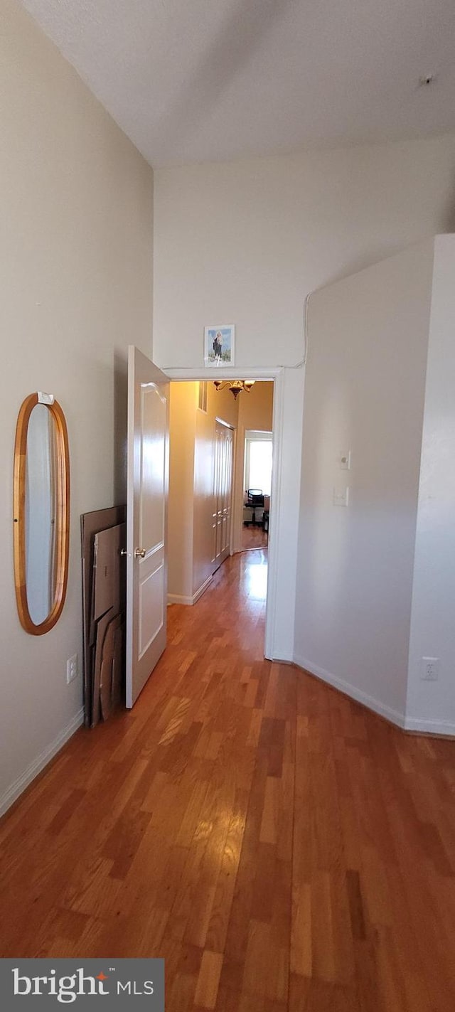 corridor with light wood finished floors and baseboards