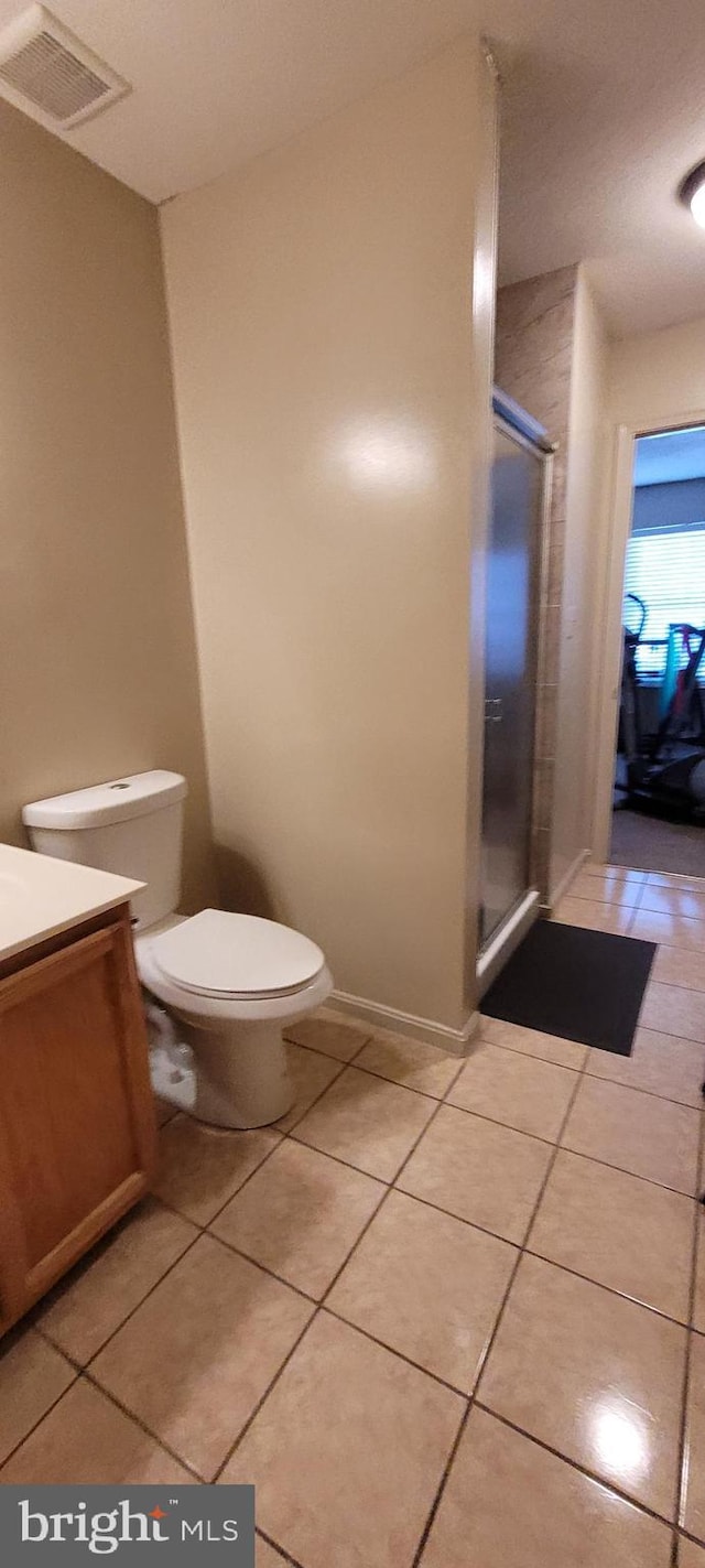 bathroom with visible vents, toilet, a shower stall, vanity, and tile patterned floors