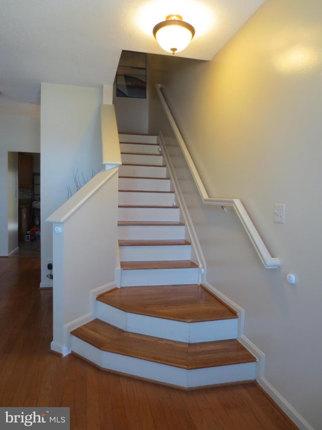 staircase with hardwood / wood-style flooring and baseboards