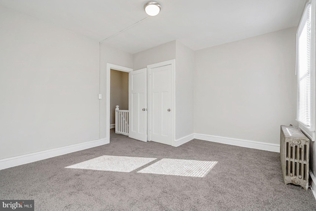 unfurnished bedroom with carpet and radiator heating unit