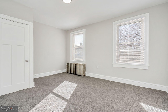 interior space with carpet and radiator heating unit