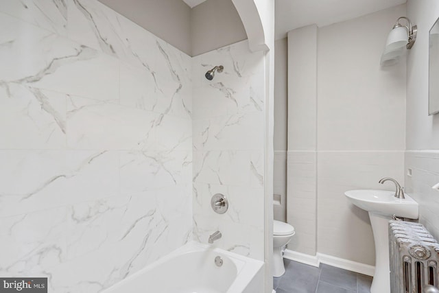 bathroom featuring tiled shower / bath, radiator heating unit, tile walls, and toilet