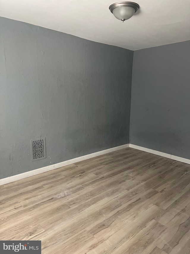 unfurnished room with hardwood / wood-style flooring