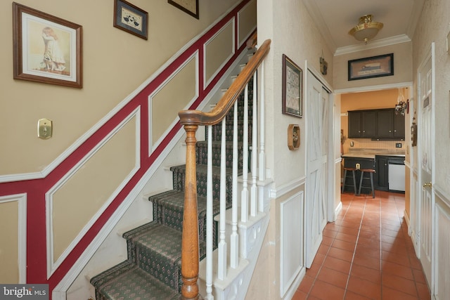 staircase with tile patterned flooring and ornamental molding