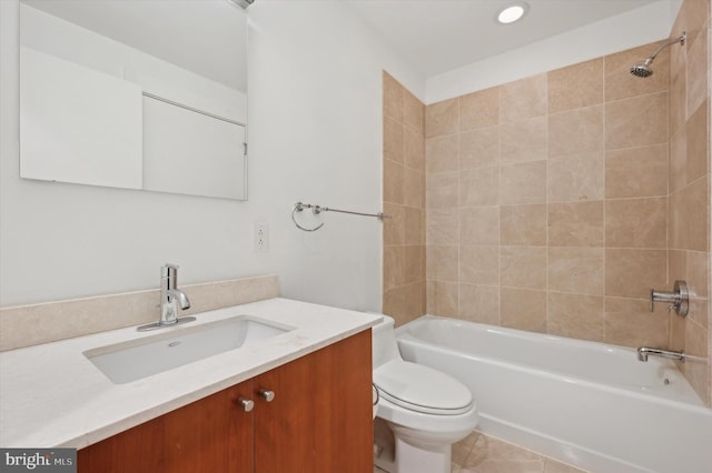 full bathroom with tile patterned flooring, vanity, tiled shower / bath combo, and toilet