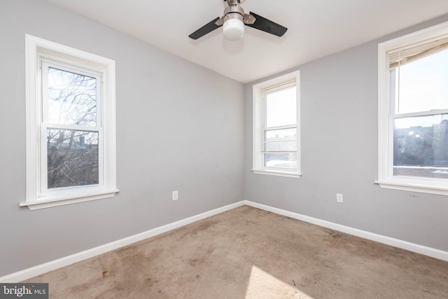 carpeted spare room featuring ceiling fan