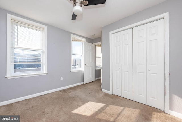 unfurnished bedroom with ceiling fan, light colored carpet, and a closet