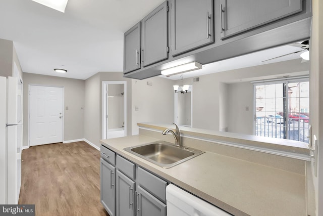 kitchen featuring sink, white appliances, light hardwood / wood-style flooring, gray cabinets, and ceiling fan