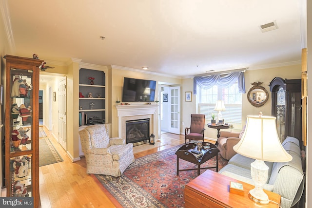 living room with light hardwood / wood-style flooring and ornamental molding