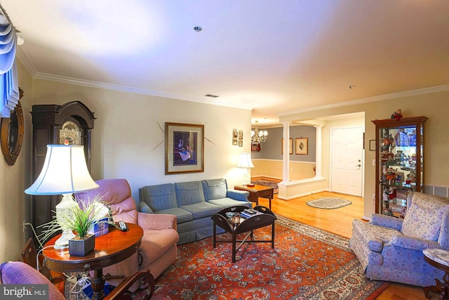 living room featuring crown molding, hardwood / wood-style floors, and a notable chandelier