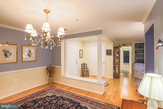 interior space with decorative columns, ornamental molding, and light hardwood / wood-style flooring