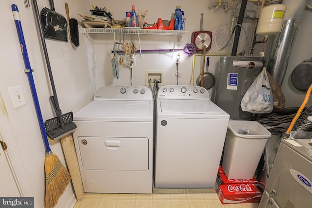 washroom with washing machine and dryer and water heater