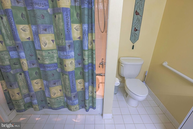 bathroom with shower / tub combo with curtain, tile patterned floors, and toilet