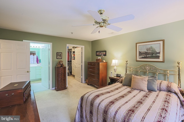 carpeted bedroom featuring ensuite bath, a closet, ceiling fan, and a spacious closet