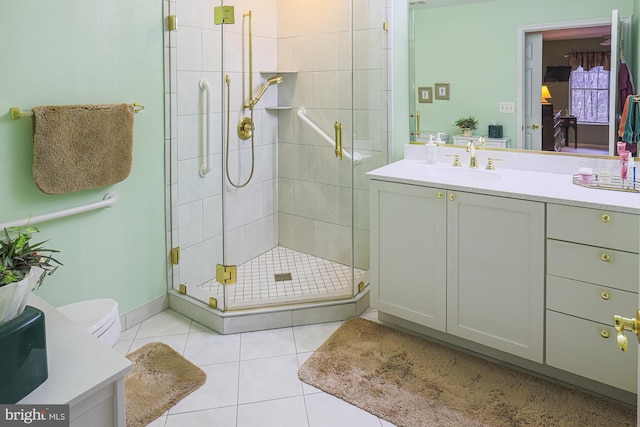 bathroom with tile patterned floors, toilet, an enclosed shower, and vanity