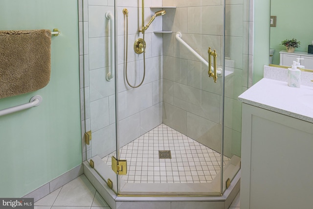 bathroom with a shower with door, vanity, and tile patterned floors