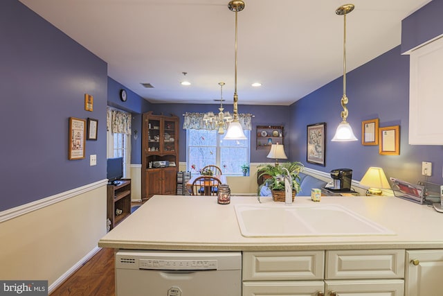 kitchen with white dishwasher, sink, pendant lighting, and dark hardwood / wood-style flooring