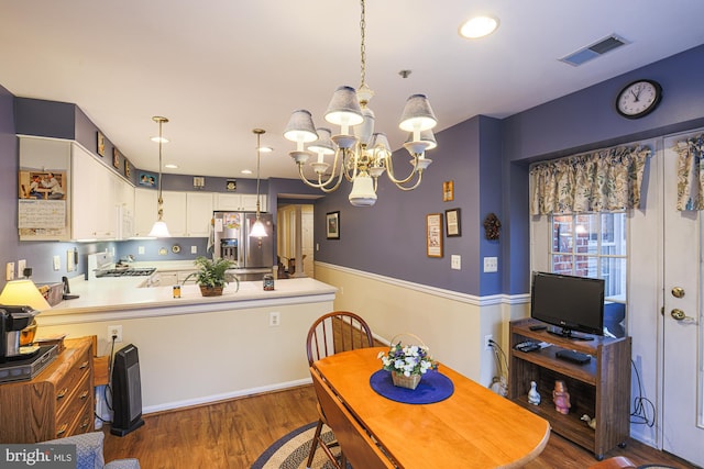 dining area featuring a notable chandelier and dark wood-type flooring