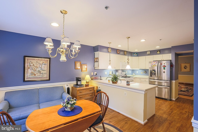 kitchen with white cabinetry, an inviting chandelier, decorative light fixtures, dark hardwood / wood-style flooring, and white appliances